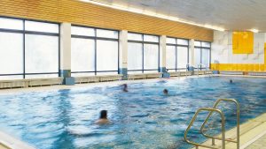 a few people swimming in a public pool